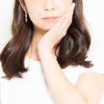 頬を抑える女性